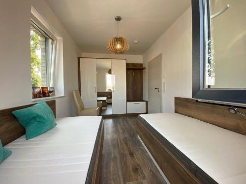 Zimmer mit 2 Betten und einem großen Fenster in der Unterkunft Ferienhaus Seestern am Harkebrügger See mit Sauna und Kamin in Barßel