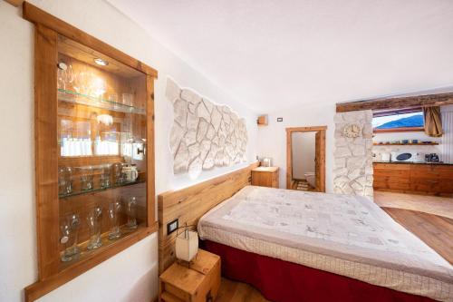 a bedroom with a bed and a stone wall at La pratolina monolocale in Castello di Fiemme