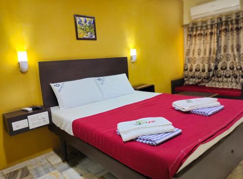 a bedroom with a bed with two towels on it at Balaji Lodge in Villupuram
