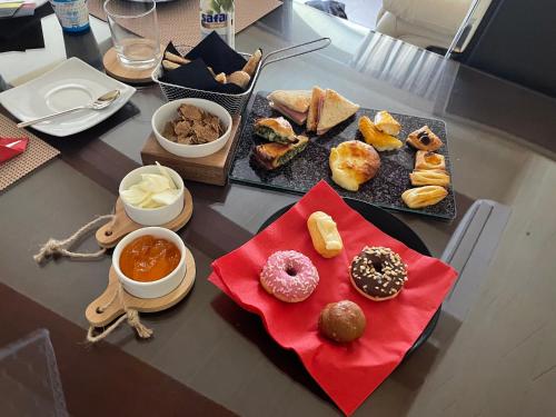 a table topped with different types of donuts and dips at Gilju B&B in Tal-Barmil