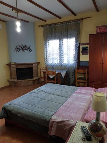 a bedroom with a large bed and a fireplace at Alexandros Guesthouse in Órma