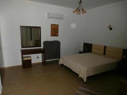 a bedroom with a bed and a window and a desk at Villa Barouti in Koinyra