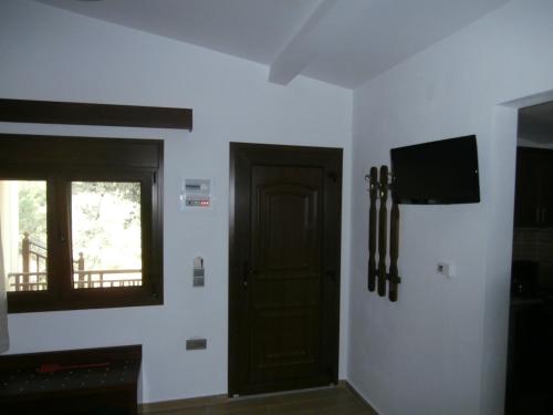 Habitación con puerta y TV en la pared en Villa Barouti, en Koinira