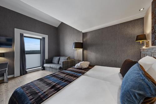 a hotel room with a large bed and a window at Castilla Termal Monasterio de Valbuena in Valbuena de Duero