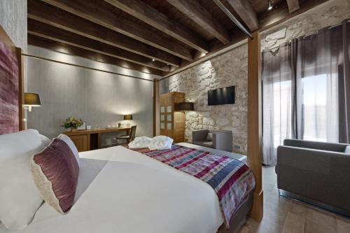 a hotel room with a bed and a desk at Castilla Termal Monasterio de Valbuena in Valbuena de Duero
