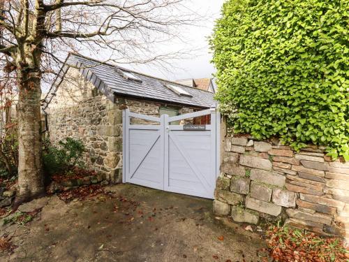 a white garage door on a stone wall at Little Orchard Barn in St Austell
