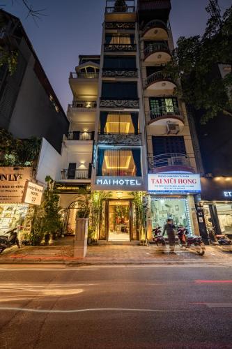a tall building with a sign in front of it at Mai Hotel in Hanoi