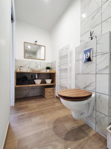 La salle de bains est pourvue de toilettes et d'un siège en bois. dans l'établissement Studio cosy Bienvenue chez Elle, à Saint-Denis-de-l'Hôtel