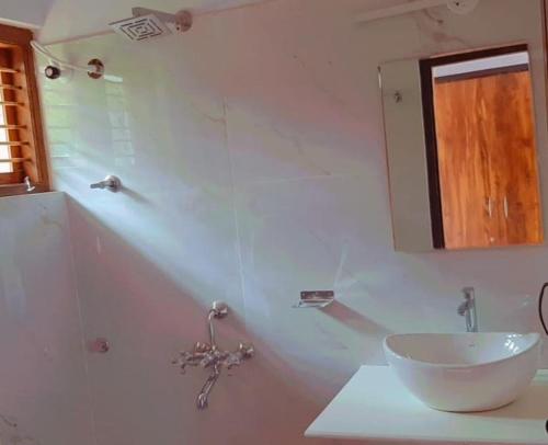a white bathroom with a sink and a mirror at Katihalli Estate Stays in Hassan
