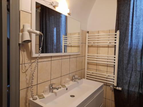 a bathroom with a white sink and a mirror at Les Buissonnets in Saint-Honoré-les-Bains