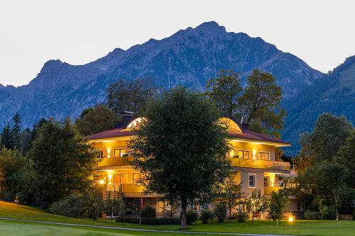 a large building with mountains in the background at Appartementhaus Tristenau in Pertisau