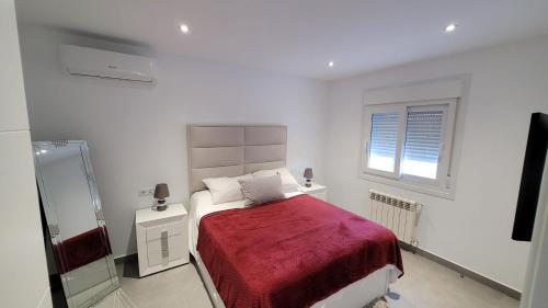 a white bedroom with a bed with a red blanket at VILLA PALMITO Mar Menor Golf in Torre-Pacheco