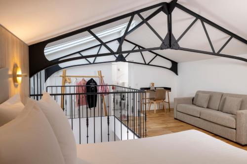 un salon avec un lit et un canapé dans l'établissement Yuna Blanche - Serviced Apartments, à Paris