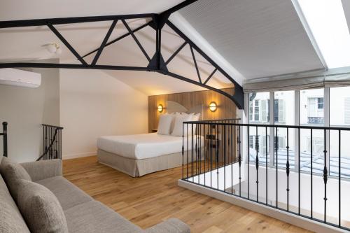 une chambre d'hôtel avec un lit et un balcon dans l'établissement Yuna Blanche - Serviced Apartments, à Paris