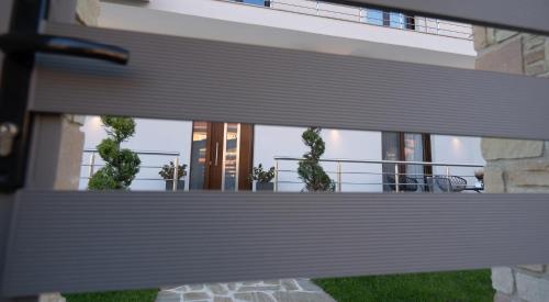 a view of a building from behind a fence at Zillis Apartments in Kato Loutraki