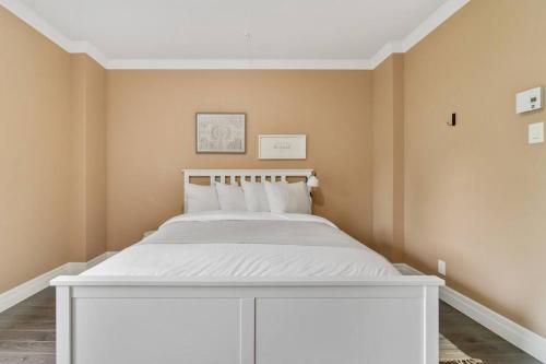 ein Schlafzimmer mit einem weißen Bett in einem Zimmer in der Unterkunft INITIAL - TEMPLE - Chutes-Montmorency in Boischâtel