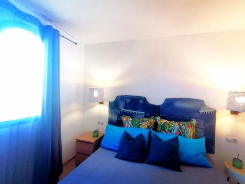 a bedroom with a blue bed with blue pillows at Oasis Waves House in Corralejo