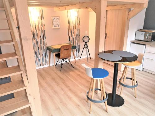 - une petite cuisine avec une table et des chaises dans une chambre dans l'établissement La Mezzanine par Picardie Homes, à Soissons