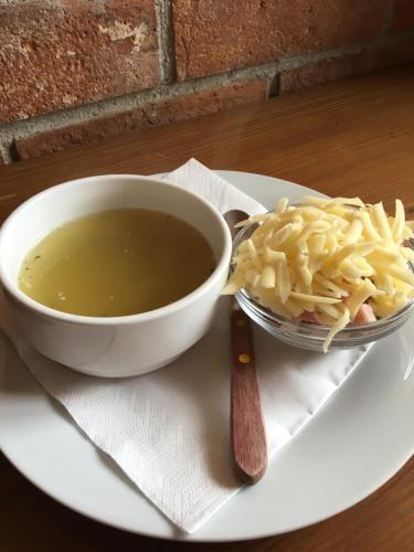 a white plate with a bowl of soup and noodles at Penzion Krcma in Dolní Morava