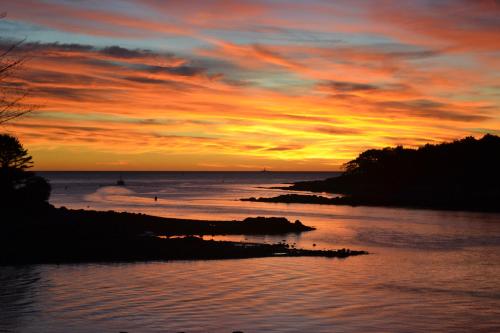 a sunset over a body of water with the sky at Dockside Guest Quarters in York