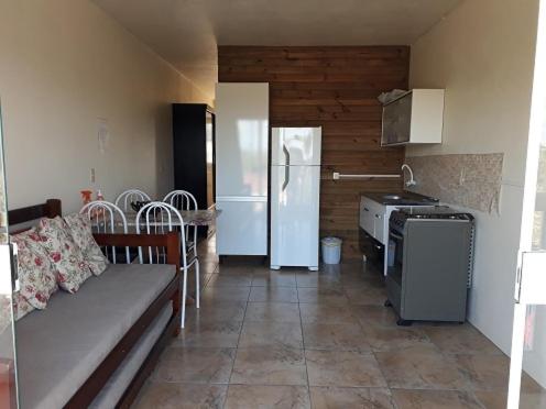 a kitchen with a couch and a stove in it at RESIDENCIAL LAGOA DUNAS in Imbituba