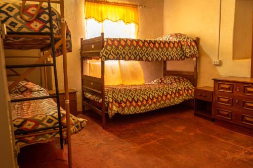 a bedroom with two bunk beds and a window at La Casa del Sol Naciente in San Pedro de Atacama