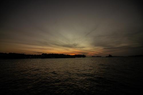 a sunset over a large body of water at Isla Los Erizos EcoHouse in Isla Grande
