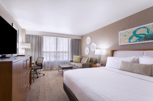 a hotel room with a bed and a flat screen tv at Holiday Inn Miami West - Airport Area by IHG in Hialeah Gardens