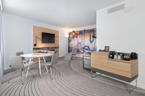 a dining room with a table and chairs in a room at Novotel London Excel in London
