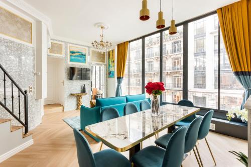 une salle à manger avec une table en verre et des chaises bleues dans l'établissement Luxury 3 bedroom 2 bathroom Apartment - LOUVRE - with AC, à Paris