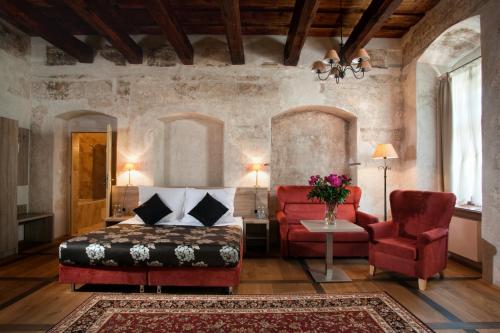 a bedroom with a bed and a couch and a chair at Hotel Santi in Kraków