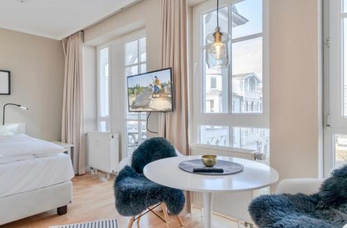 奧斯賽拜－塞林的住宿－Sehnsucht Rügen Ferienappartements，卧室配有一张床和一张桌子及椅子