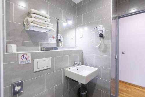 a bathroom with a sink and a mirror at Hôtel Edmond Rostand in Marseille