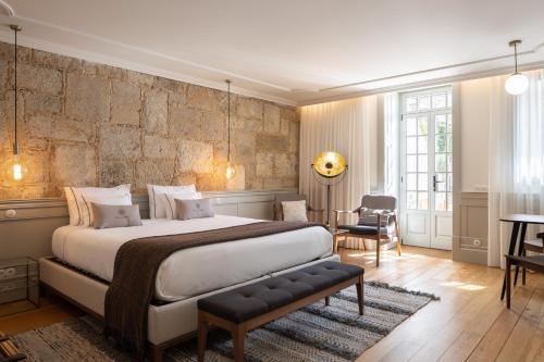 um quarto com uma cama grande, uma mesa e cadeiras em CASA CAMÉLIA no Porto