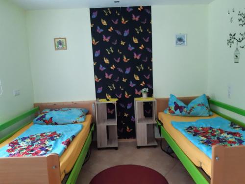 duas camas num quarto com borboletas na parede em Monikas Gästehäuser Seeblick Himmelpfort em Pian