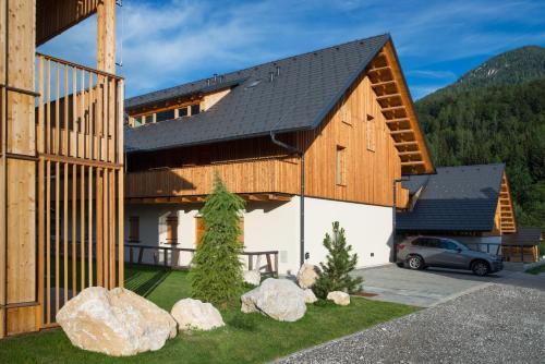 a barn with a car parked in front of it at Apartments Maison in Kranjska Gora