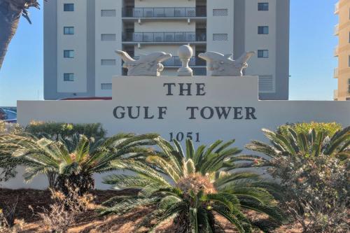 a sign for the gulf tower in front of palm trees at Gulf Tower 14W in Gulf Shores
