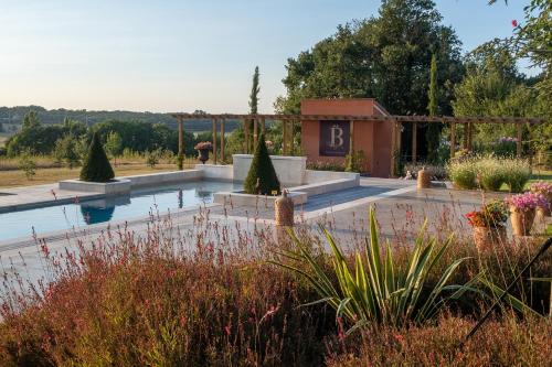 une piscine dans un jardin avec un bâtiment en arrière-plan dans l'établissement Chambre d'hôtes Belair, à Muret