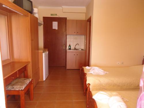 a small room with two beds and a kitchen at FAFALIOS Studios in Vrontados