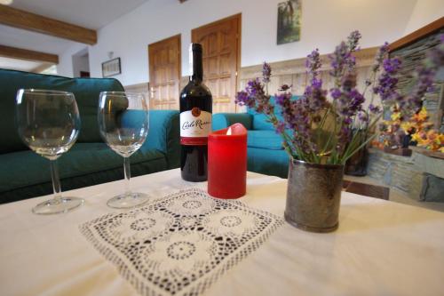 ゾンプにあるPOKOJE KOZICAのグラス2杯、ワイン1本、花