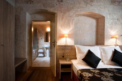 a bedroom with a large bed and a bathroom at Hotel Santi in Kraków
