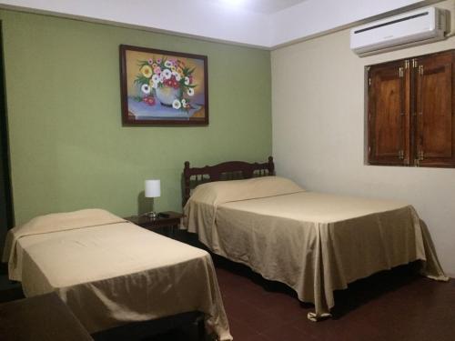 Habitación con 2 camas y una pintura en la pared. en Hotel Vizcaíno León en León