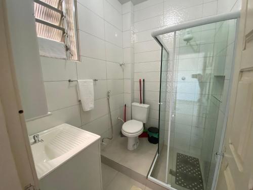 uma casa de banho com um WC e uma cabina de duche em vidro. em Apto a beira mar no Centro - WIFI 200MB - TV Smart - Cozinha equipada - Portaria 24h - Ar condicionado em Rio das Ostras