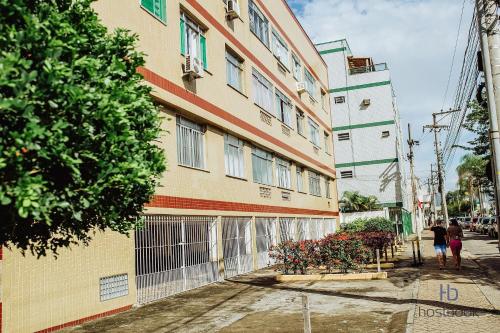 a building on a street with people walking past it at Apto beira-mar no centro | ROMM303 in Rio das Ostras