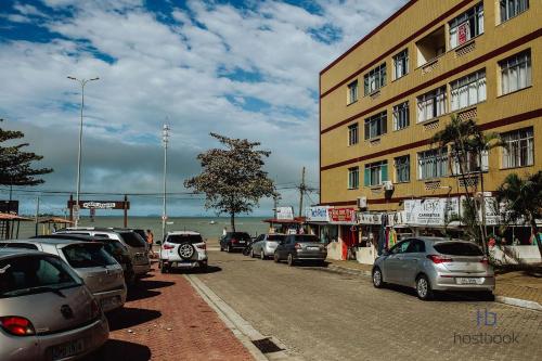 a street filled with cars parked next to a building at Apto beira-mar no centro | ROMM303 in Rio das Ostras