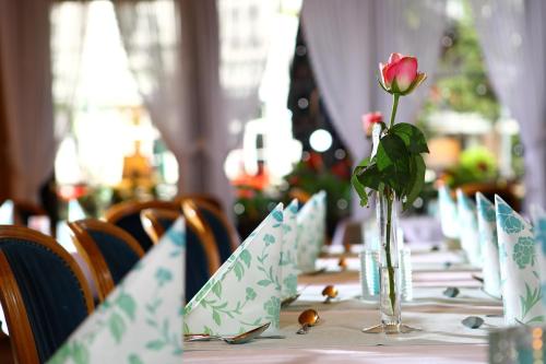 a long table with a rose in a vase on it at Hotel-Restaurant Wanders in Elten