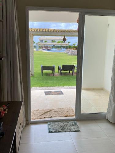 an open door to a patio with two benches outside at Boas Vistas Canoa Quebrada in Aracati