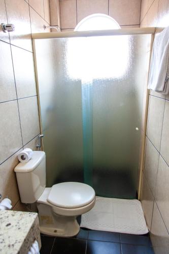 a small bathroom with a toilet and a shower at Vila Verde Hotel in Toledo