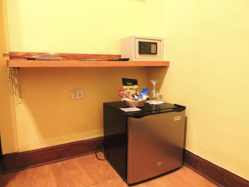 a small refrigerator in a room with a microwave at Lima Wari Hotel Boutique in Lima