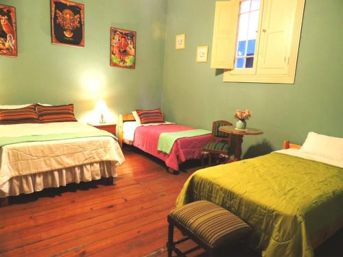 a bedroom with two beds and a table and a window at Lima Wari Hotel Boutique in Lima
